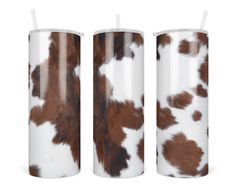 two tumbles with brown and white spotted cowhide pattern on them, one has a straw in it