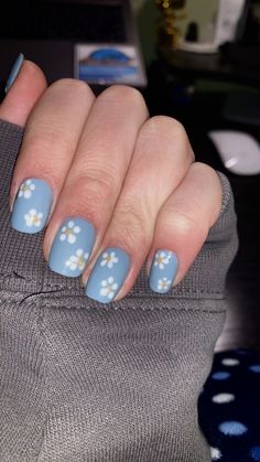 Short square nails with baby blue base and white summer flowers. Set with a glossy top coat. Blue Cloud Nails Short, Blue With White Flower Nails, Cornflower Blue Nails Design, Baby Blue Flower Nails, Baby Blue Nails With Flowers, Unc Nails, White Nails With Blue Flowers, Blue Nails With White Flowers, Baby Blue Summer Nails