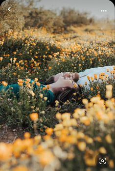 a person laying on the ground in a field full of yellow flowers with their eyes closed