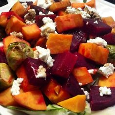 a white plate topped with beets, brussel sprouts and feta cheese