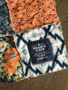 four different fabric squares are stacked on top of each other, one has an orange and blue flower