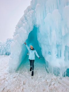 a woman standing in front of an ice cave