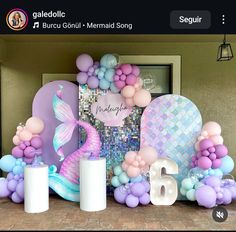 there are balloons and decorations on the mantle in front of the door to be decorated with mermaid theme