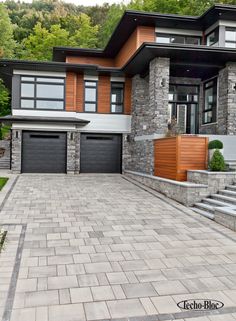 a large house with two garages and steps leading up to the front door,