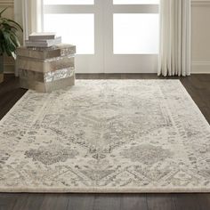 a white rug with an ornate design on the floor in front of a door and window