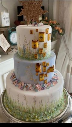 a three tiered cake is decorated with flowers and gold crosses on the top layer