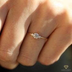 a woman's hand with a diamond ring on top of her finger, showing the side view