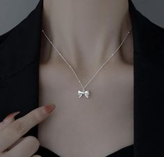 Add a touch of sophistication and charm to any outfit with this stunning Silver Bow Pendant Necklace. Crafted with meticulous attention to detail, this necklace features a delicate bow pendant that exudes timeless elegance. Features: - Material: High-quality sterling silver - Design: Intricately designed bow pendant for a classic and feminine look - Chain Length: Adjustable chain for a perfect fit, ranging from 16 to 18 inches - Clasp: Secure lobster clasp for easy wear and removal Highlights: - Versatile Style: Perfect for everyday wear or special occasions - Elegant Finish: Polished silver finish that shines beautifully - Gift-Ready: Ideal gift for birthdays, anniversaries, or any special occasion Care Instructions: - Store in a cool, dry place when not in use - Avoid contact with water Silver Bow Necklace For Wedding, Silver Bow Jewelry As A Gift, Delicate Silver Jewelry With Bow Detail, Delicate Silver Jewelry With Bow, Silver Bow Jewelry For Gift, Elegant Sterling Silver Necklace With Bow, Silver Sterling Silver Necklace With Bow, Elegant Sterling Silver Jewelry With Ribbon, Elegant Silver Jewelry With Bow Detail