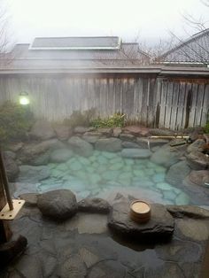 an outdoor hot tub surrounded by rocks and lights