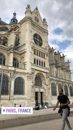 a man walking in front of a large building with a sign that says paris, france