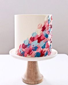 a white cake with red, blue and pink icing