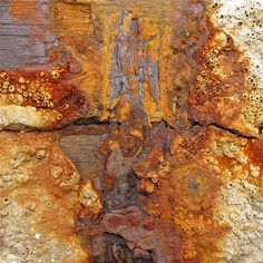 an old rusted metal surface with yellow and brown paint