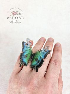 This butterfly ring who beautifully captures the magic of nature is an outfit changer and a real eye-catcher. Looks gorgeous with anything! Handcrafted from soft natural silk, this ring features a beautiful butterfly that will brighten up your look. The base of the ring is adjustable, so it will fit any finger size. Product specifications:     * handmade of silk;     * wingspan is about 5 cm     * adjustable size;     * the butterfly has three layers of silk;     * realistic look. Due to the pro Handmade Iridescent Jewelry In Butterfly Shape, Iridescent Butterfly-shaped Handmade Jewelry, Handmade Iridescent Butterfly Jewelry, Unique Handmade Butterfly Ring, Bohemian Butterfly Ring As A Gift, Bohemian Butterfly Ring As Gift, Handmade Butterfly Rings For Wedding, Handmade Butterfly Wedding Rings, Handmade Butterfly Shaped Wedding Rings