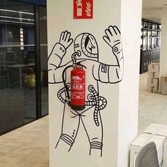 a fire extinguisher painted on the side of a wall in an office building