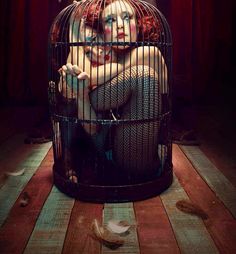 a poster for the show ahs, featuring a woman in a cage with her head inside