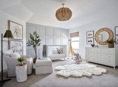 a bedroom with white furniture and pictures on the wall, including a baby's crib