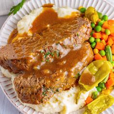 meatloaf with gravy, mashed potatoes and vegetables on a paper plate