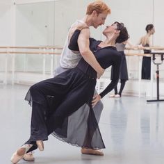 two people are dancing in a dance studio with one holding the other's leg