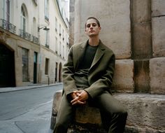 a man sitting on the side of a building