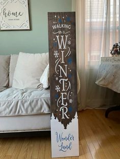 a wooden sign sitting on top of a hard wood floor next to a white couch