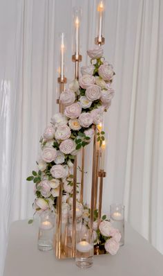 a tall vase filled with flowers and candles