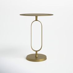 a round table with a metal base and a gold plate on the top that is holding a circular object