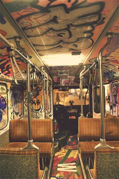 the inside of a bus with graffiti all over it