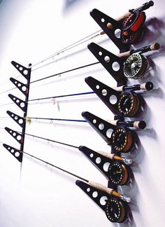 an assortment of different types of bow and arrow bows are arranged in a row on a white wall