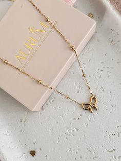 Explore the elegance of Hermaine, our 18K Gold Plated Bow Necklace. Bows and knots aren't just pretty; they carry meanings of eternity, remembering, and being 'tied' together in a special way. Hermaine Bow Necklace is crafted from sturdy stainless steel and coated with a strong 18K gold plating. It is ideal for everyday wear. This necklace is also hypoallergenic, which promises you comfort and chic vibes. Elevate your style effortlessly with this timeless piece. Chain length: 45+5cm Bow size: 15 Dainty Tarnish Resistant Chain Necklace Gift, Elegant Gold-plated Necklaces Suitable For Gifting, Elegant Gold-plated Necklaces, Elegant Gold Plated Necklaces For Gifts, Gold Plated Chain Necklace Gift, Gold Clavicle Chain Necklace As Gift, Gold Minimalist Necklace For Gift, Minimalist Plated Chain Necklace As Gift, Elegant Yellow Gold Charm Necklace