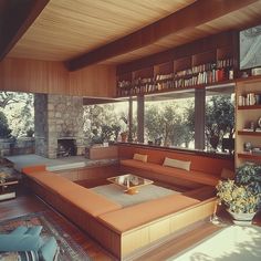 a living room filled with lots of furniture and bookshelves next to a fire place