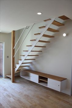 an empty room with a wooden floor and stairs