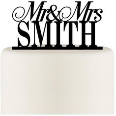 a wedding cake topper with the word mr and mrs in black lettering on it