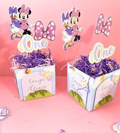 two boxes filled with purple flowers and minnie mouse decorations