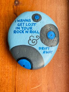 Hand painted on a natural textured river rock are some of this song lyrics to Drift Away by Dobie Gray.   Featuring a vinyl records.   Please note this is a natural rock with natural imperfections.  The back is not painted so that you may see the raw rock. Measures 3 1/2" x 3 " x 1 1/2". Sealed with gloss varnish to help preserve the art. Painted Rocks With Words, River Rock Art, Rock Song Quotes, Rock Painting Designs Simple, Hiking Rock Art, Memorial Rocks Painted, Funny Rock Painting Ideas, Painted Rocks Camping Theme, You Rock Rock Painting