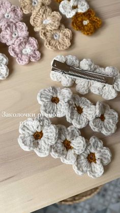 several crocheted flowers are sitting on a table with a comb in the middle