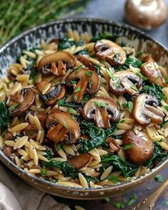 a bowl filled with pasta and mushrooms on top of a table