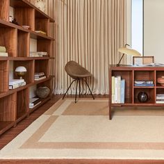 a living room with bookshelves and a chair next to a large book shelf