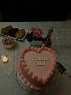 a heart shaped cake sitting on top of a table next to wine glasses and plates