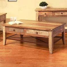 a wooden coffee table sitting on top of a hard wood floor next to two end tables