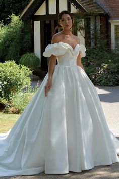 a woman in a white wedding dress standing outside