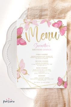 a pink and gold butterfly birthday party menu on a white plate next to a napkin