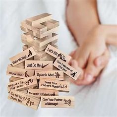 a pile of wooden blocks with words written on them and hands reaching for each other