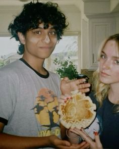 a young man and woman holding food in their hands