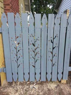 a blue wooden fence with flowers painted on it