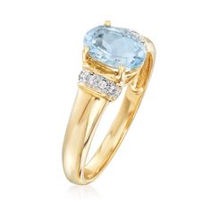 a gold ring with an aqua blue topazte and diamonds