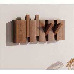 a wall mounted wooden sculpture on the side of a white wall