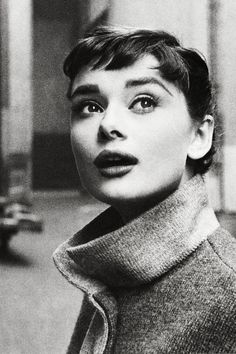 a black and white photo of a woman with short hair wearing a turtle neck sweater