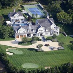 an aerial view of a large house with a tennis court in the middle of it