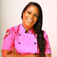 a woman in a pink chef's uniform with her arms crossed