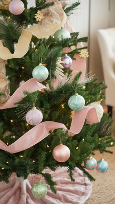 a decorated christmas tree with pink ribbon and ornaments